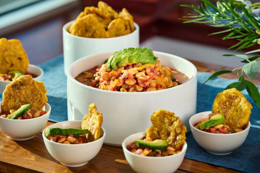 A meal served with a side of fried plantains accompanied by small bowls containing the meal 